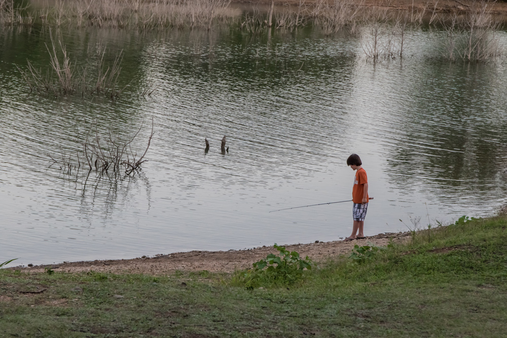 kid fishing on the shoreline by heather valey