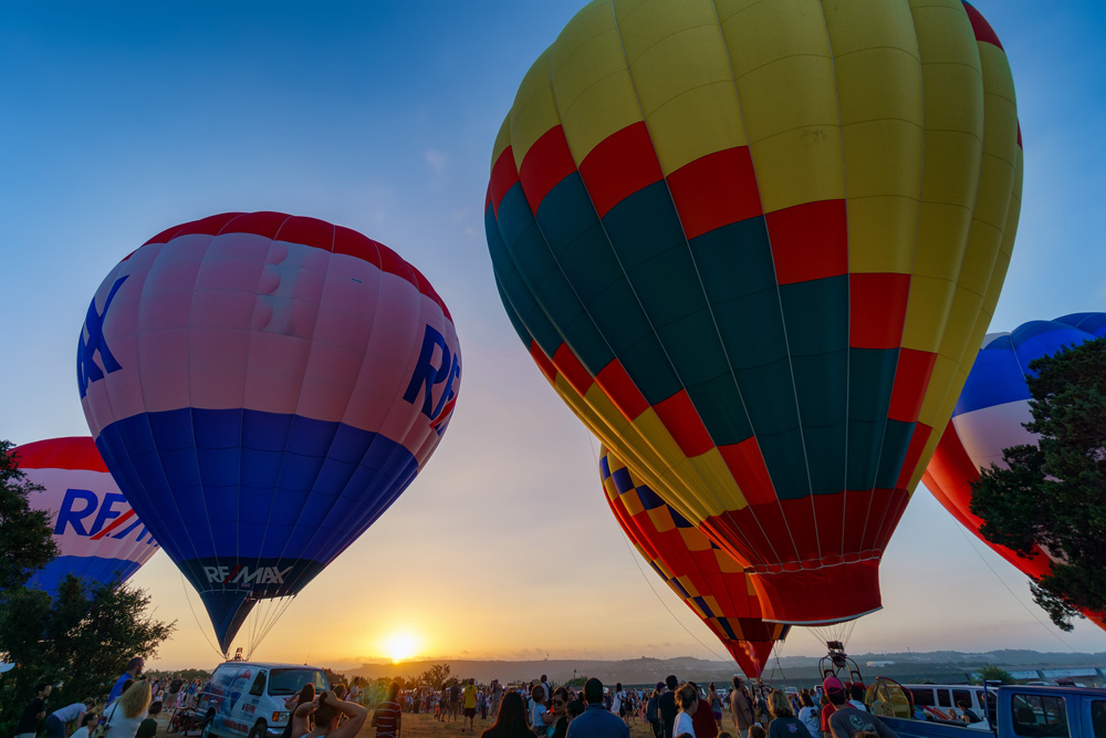 hot air balloons over crowd of people by jaco botha 